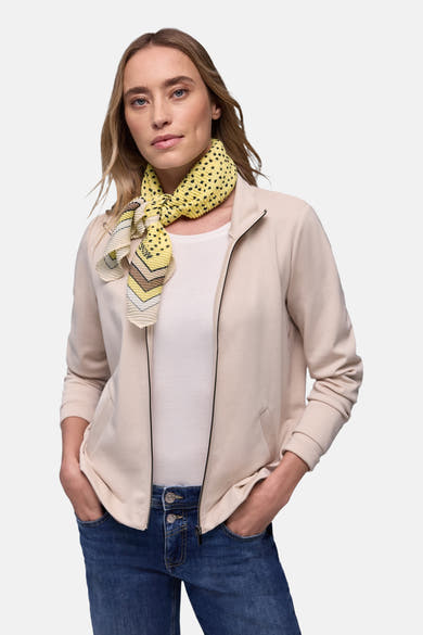 Foulard multicolore de Street One, à motif géométrique et à pois, porté avec une veste beige et un jean bleu.
