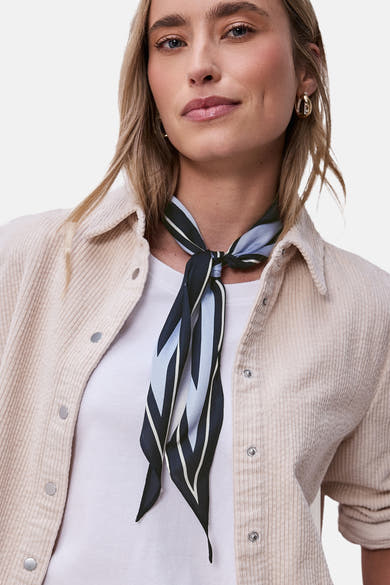 Foulard bleu STREET ONE à rayures noué autour du cou, porté avec une veste en velours côtelé crème.