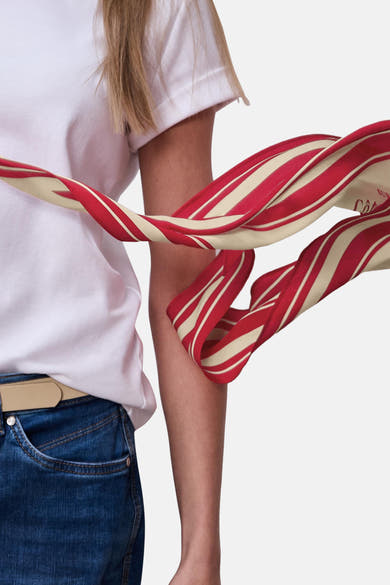Foulard multicolore de STREET ONE, motif à rayures rouges et crème, porté avec un jean et un t-shirt blanc.
