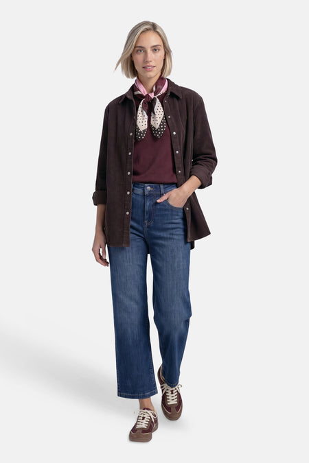 Multicolored foulard with polka dot pattern tied around neck, worn with corduroy shirt and blue jeans in full-length lifestyle view