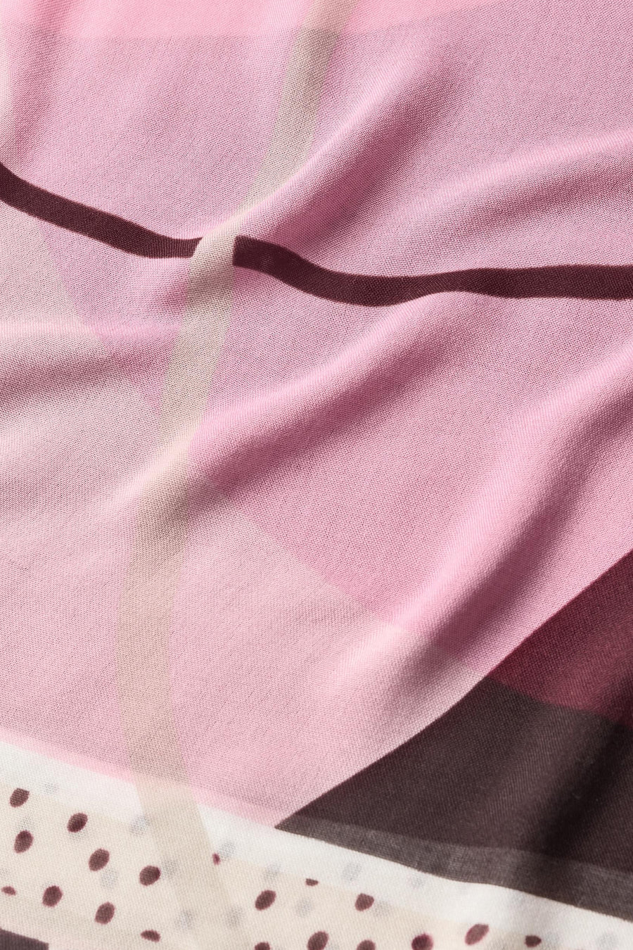 Multicolored foulard with pink base, dark wavy stripes, and polka dot border, soft sheer fabric, close-up view