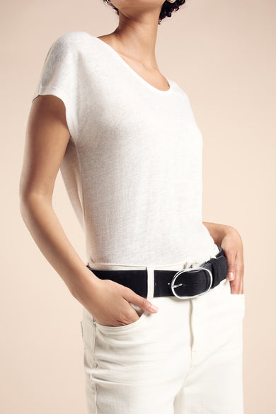 Ceinture noire par STREET ONE, avec une boucle ovale argentée portée avec un t-shirt blanc et un jean blanc.
