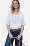 Ceinture cognac de STREET ONE portée avec un jean bleu et une chemise blanche, tenant un sac en daim marron.
