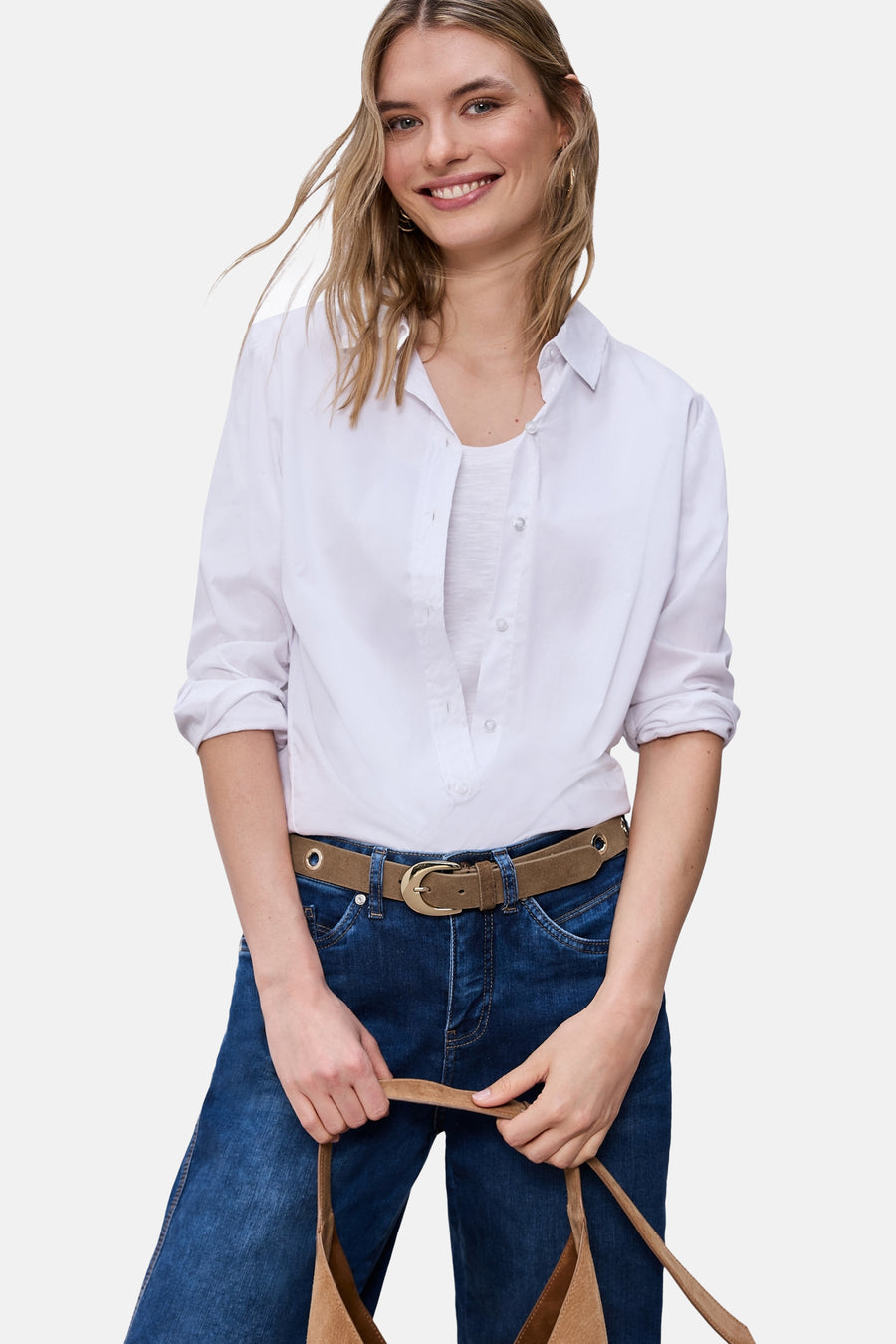Ceinture cognac de STREET ONE portée avec un jean bleu et une chemise blanche, tenant un sac en daim marron.
