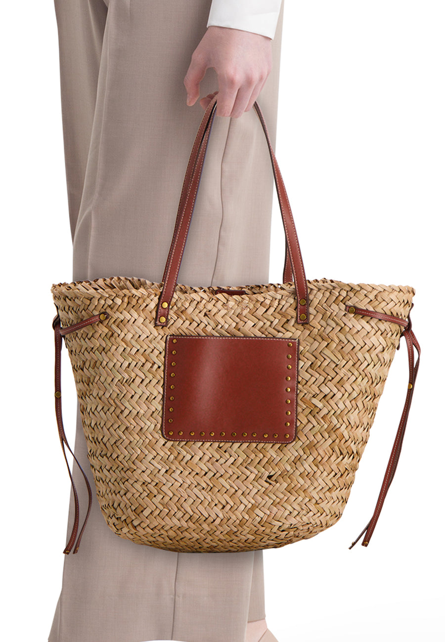 Sac à bandoulière en paille tressée de STREET ONE avec poignées en cuir marron et poche frontale à rivets dorés.