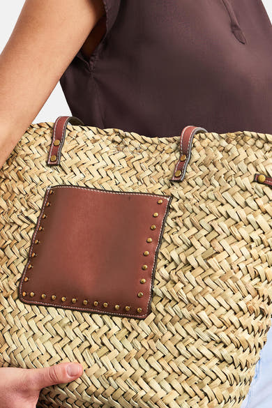 Sac à bandoulière beige de STREET ONE en paille tressée avec poche et poignées en cuir marron cloutées, tenu.