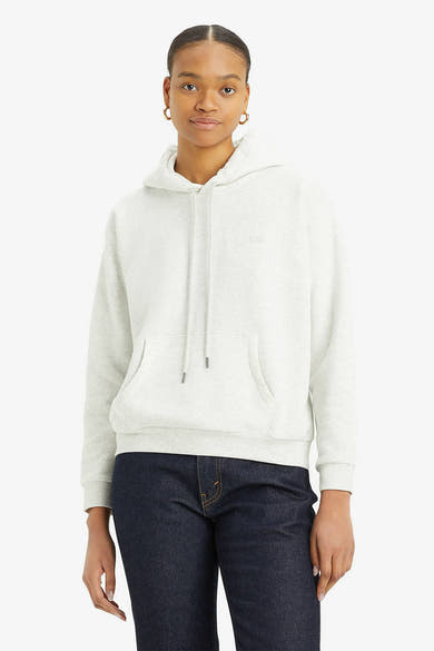 Sweat à capuche gris par Levi's, avec cordon de serrage et poche kangourou, porté avec un jean bleu marine.
