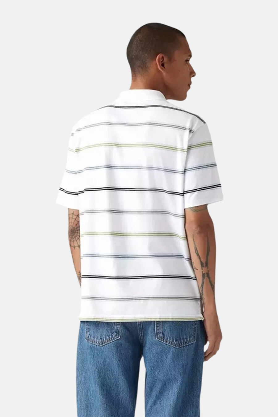 Wit gestreept poloshirt met korte mouwen van Levi's, met zwarte, blauwe en groene strepen, gedragen met een spijkerbroek.