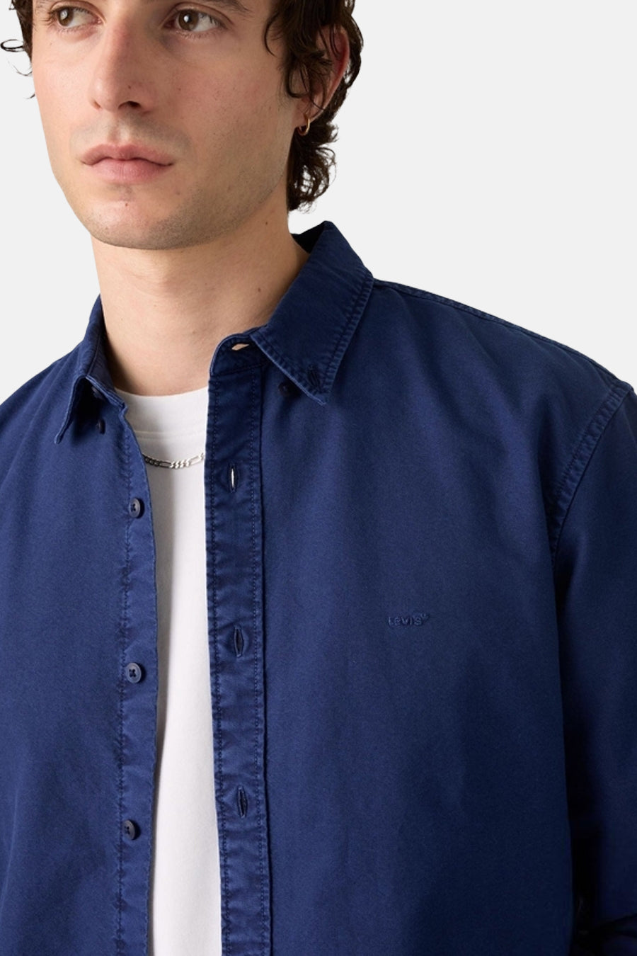 Navy blue long-sleeve shirt by Levi's with classic collar, button-down front, and chest logo, worn over white tee, close-up front view
