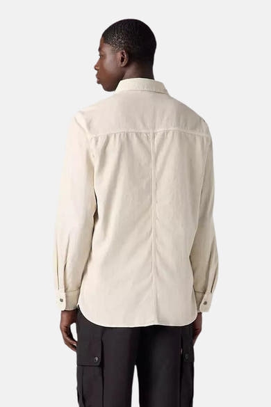 Chemise beige à manches longues de Levi's, avec détails de couture verticaux au dos, portée avec un pantalon cargo noir.
