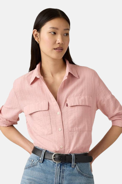 Chemise rose à manches longues de Levi's, avec poches poitrine plaquées et ceinture en cuir noir.
