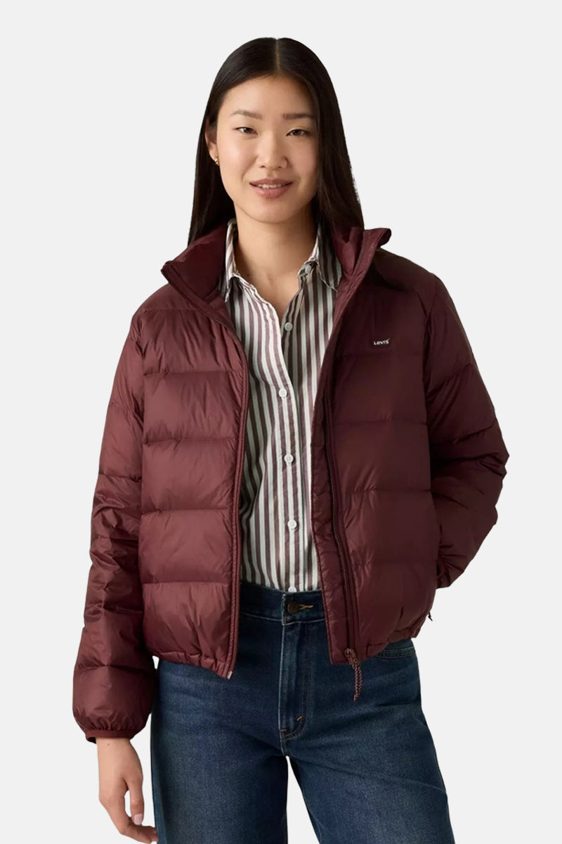 Korte bordeauxrode jas van Levi's, gedragen over een verticaal gestreept overhemd en een blauwe spijkerbroek.
