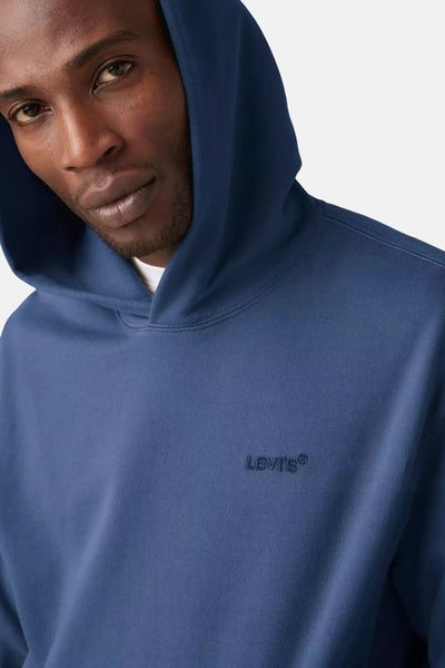 Sweat à capuche bleu de Levi's®, porté par un homme, capuche relevée.