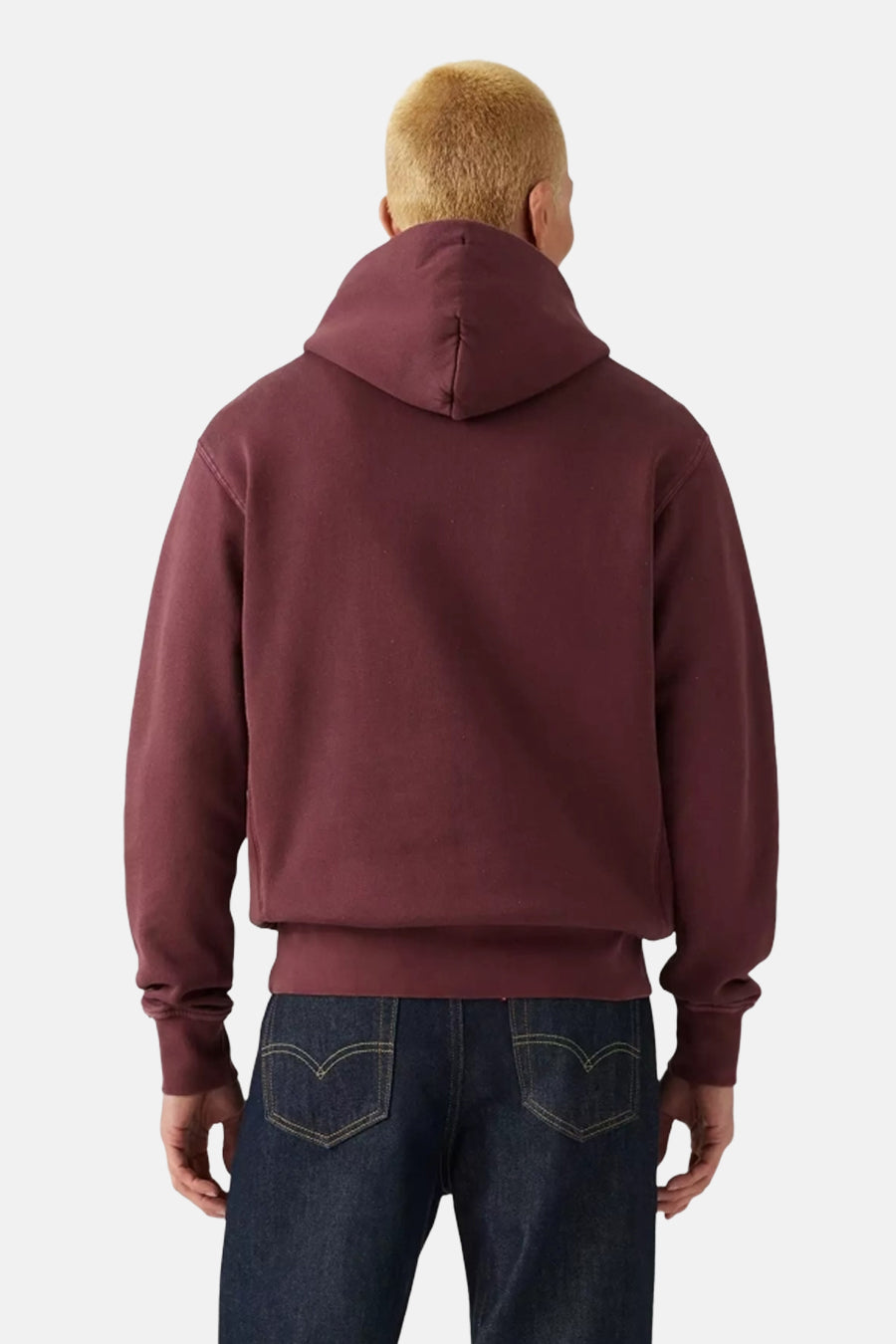 Sweat à capuche bordeaux de Levi's®, vue de dos, porté avec un jean bleu foncé.
