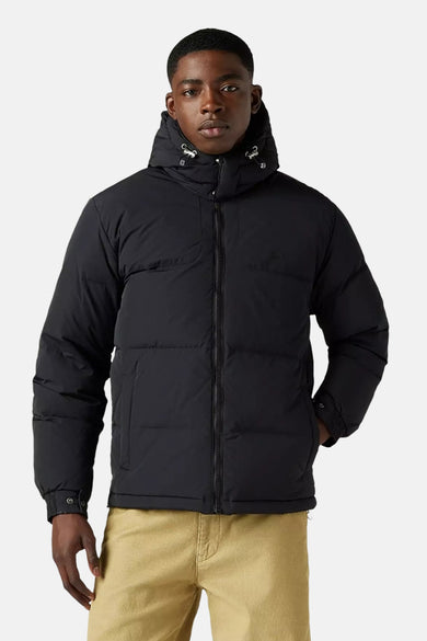 Veste courte noire par Levi's® avec capuche et fermeture éclair, portée avec un pantalon couleur sable.