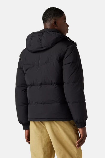 Veste courte noire de Levi's, avec capuche, portée avec un pantalon couleur sable, vue de dos.