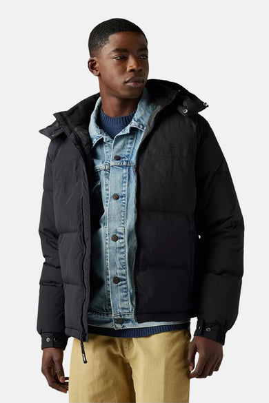 Veste courte noire de Levi's®, portée sur une veste en jean et un pull bleu