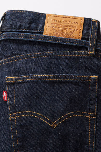 Rechte donkerblauwe spijkerbroek van Levi's®, achterzakdetail met rood label en logo.
