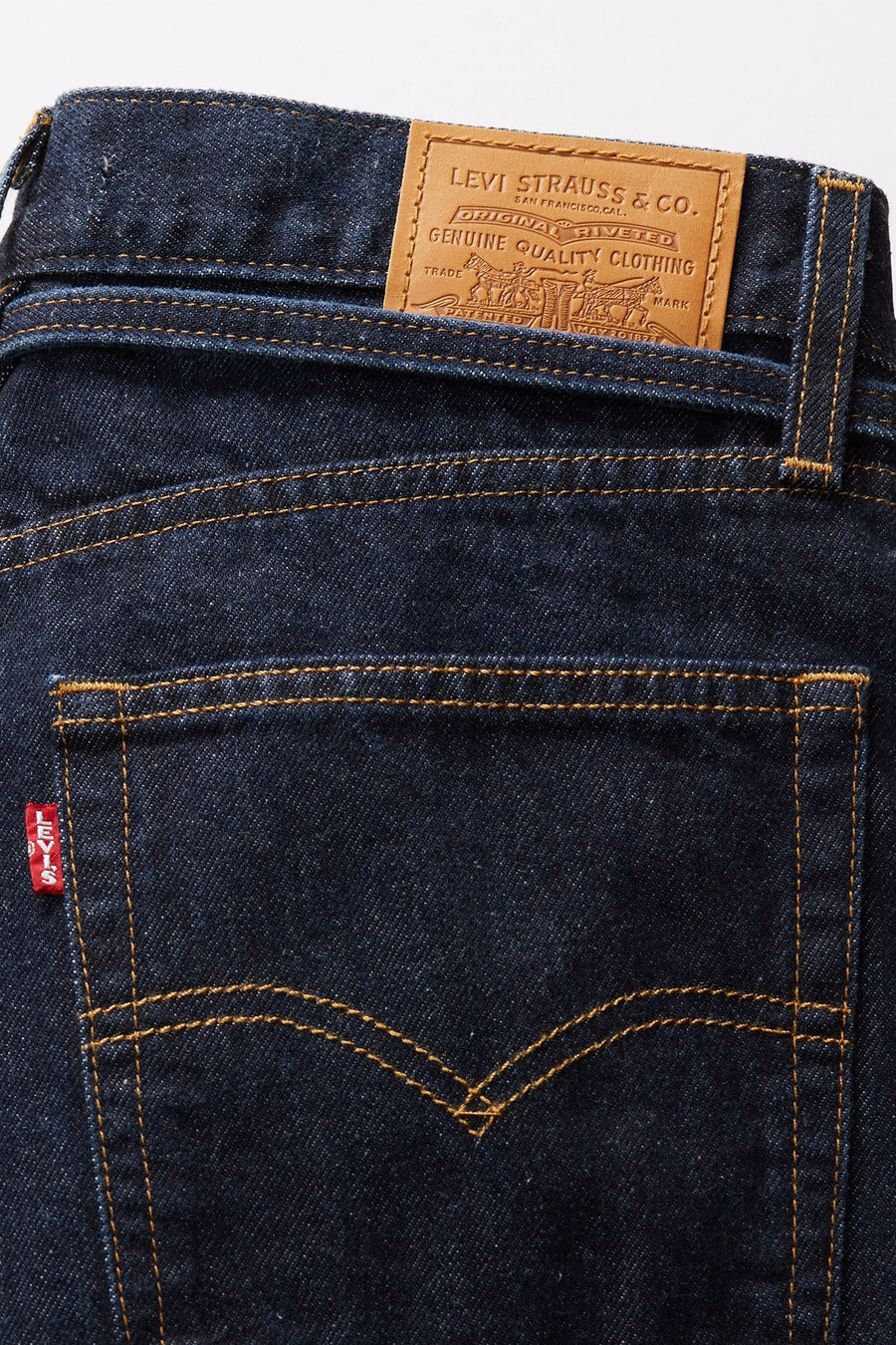 Rechte donkerblauwe spijkerbroek van Levi's®, achterzakdetail met rood label en logo.
