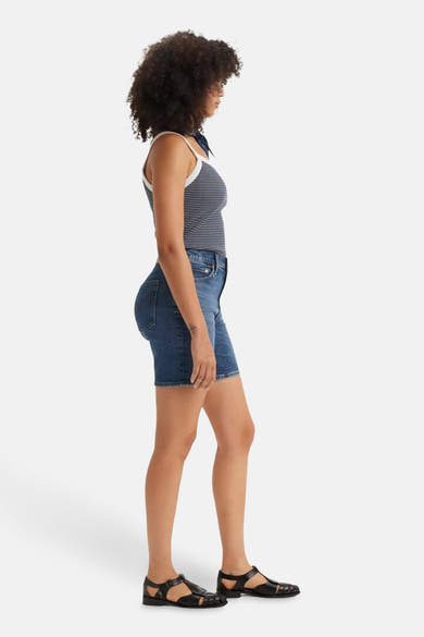 Short en denim par Levi's®, coupe classique bleu moyen, porté avec un débardeur rayé et des sandales noires.