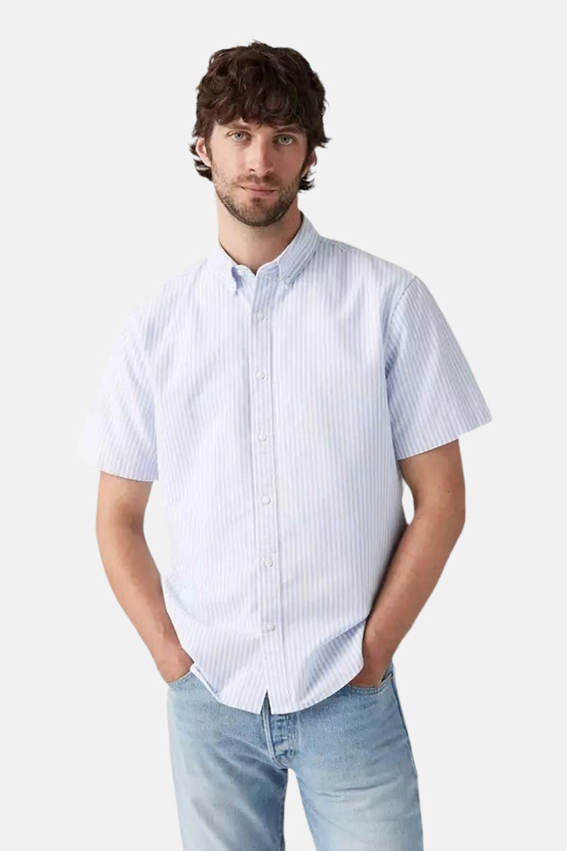 Blauwe gestreepte blouse met korte mouwen van Levi's, gedragen met een lichte spijkerbroek en handen in de zakken.