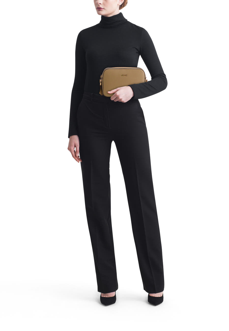 Sac à bandoulière vert de LIU JO, porté avec un pull noir à col roulé et un pantalon noir élégant.