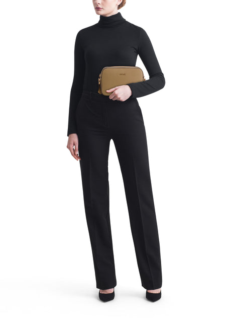 Sac à bandoulière vert de LIU JO, porté avec un pull noir à col roulé et un pantalon noir élégant.