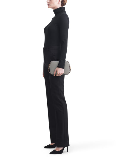 Sac à bandoulière bleu de LIU JO, porté avec un pantalon et un pull noirs, vue de côté.
