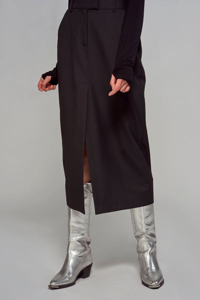 Zwarte lange rok van ASTRID Black Label, met een split en gedragen met zilveren laarzen.