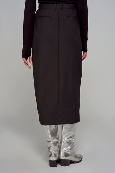 Zwarte lange rok van ASTRID Black Label, gedragen met zilveren laarzen en een zwart shirt met lange mouwen, van achteren gezien.
