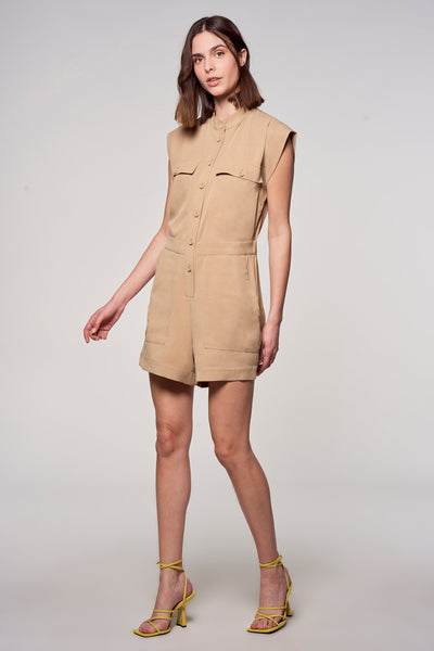 Combi-short beige de ASTRID Black Label, avec manches courtes, poches et sandales jaunes à talons.
