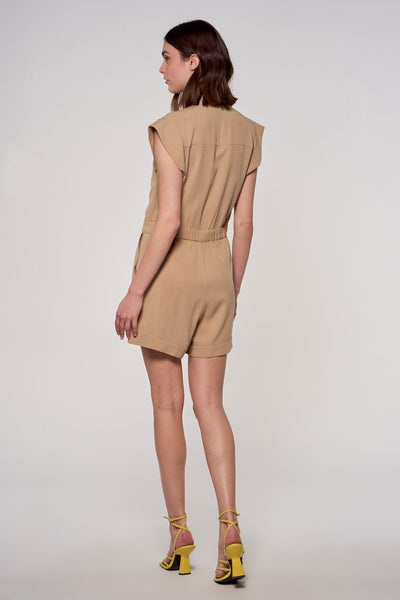 Beige combishort van ASTRID Black Label, gedragen met gele hoge hakken, van achteren gezien.