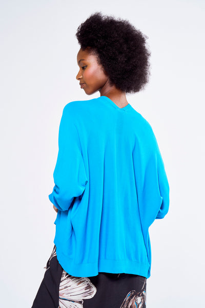 Gilet bleu by ASTRID Black Label, porté sur un pantalon à motif floral, vue de dos.