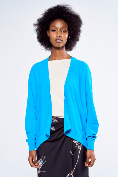 Gilet bleu ASTRID Black Label porté sur un t-shirt écru et une jupe noire à motifs floraux.