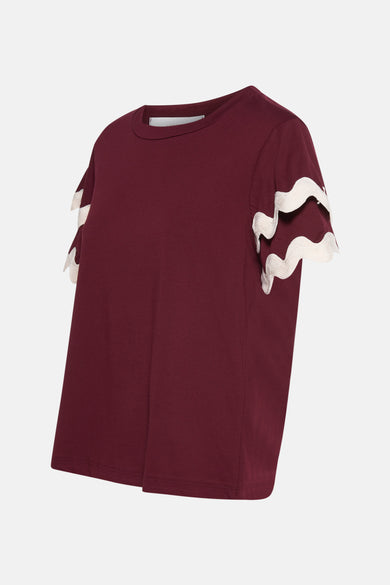 T-shirt bordeaux à manches courtes par AMELIE ET AMELIE, avec détails festonnés blancs sur les manches.