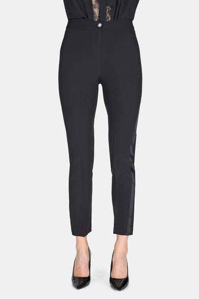 Pantalon coloré noir d'ARTIGLI, avec une bande latérale satinée, porté avec des escarpins vernis noirs.
