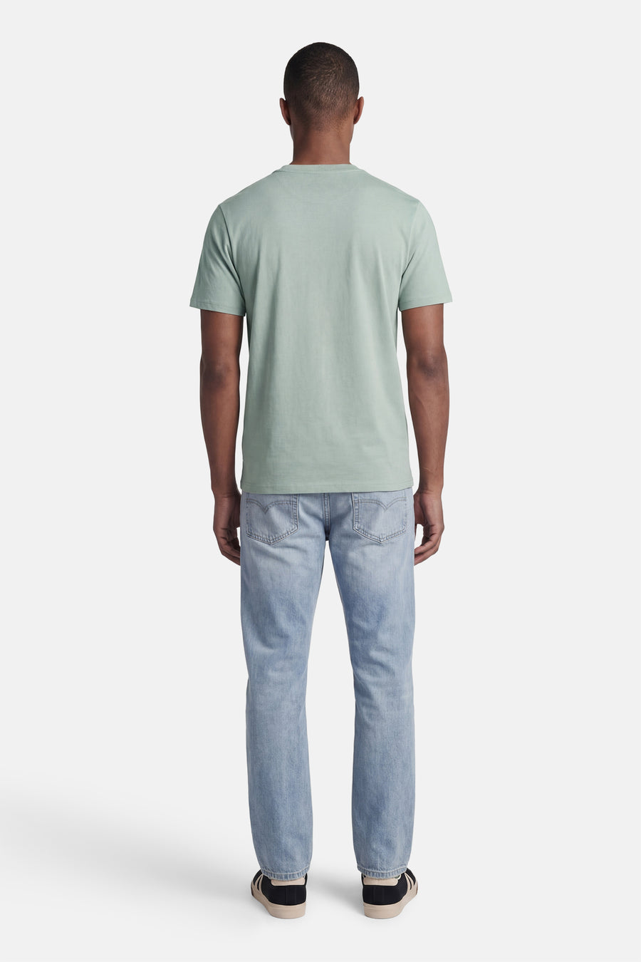 Groen STROM T-shirt met korte mouwen, van achteren gedragen met een lichtblauwe jeans en sneakers.