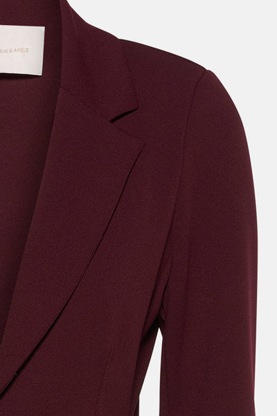 Blazer bordeaux par Amélie et Amélie, avec revers crantés et texture fine.