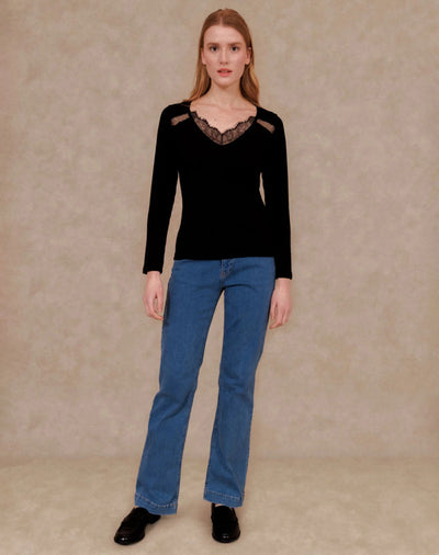 Black long-sleeve T-shirt with lace V-neck and shoulder cutouts, worn with blue jeans and black shoes, full-length front view