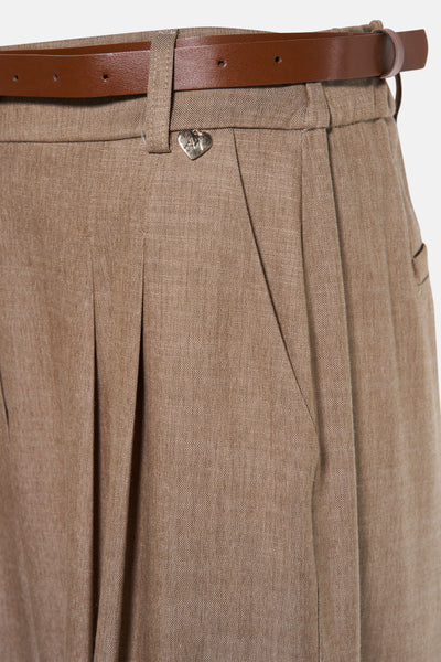Beige kostuumbroek van AMELIE ET AMELIE met plooien, bruine riem en decoratief hartdetail.