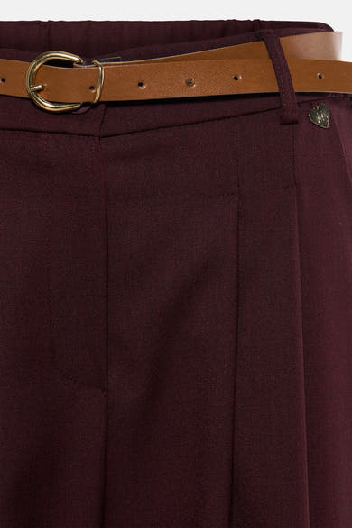 Pantalon de costume rouge bordeaux de AMELIE ET AMELIE, avec ceinture marron à boucle dorée et pli marqué.