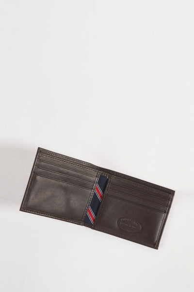 Portefeuille marron en cuir par Tommy Jeans avec doublure rayée bleu marine, rouge et blanc.