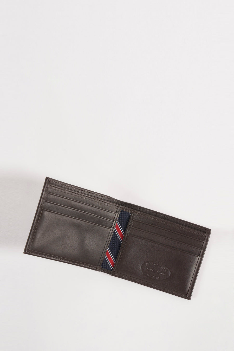 Portefeuille marron en cuir par Tommy Jeans avec doublure rayée bleu marine, rouge et blanc.