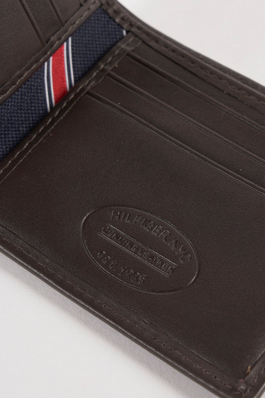 Portefeuille en cuir marron par Tommy Jeans avec rayures bleu marine, blanches et rouges.