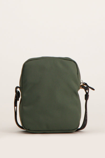 Sac à bandoulière vert de TOMMY JEANS, avec une bandoulière noire et une fermeture éclair argentée.
