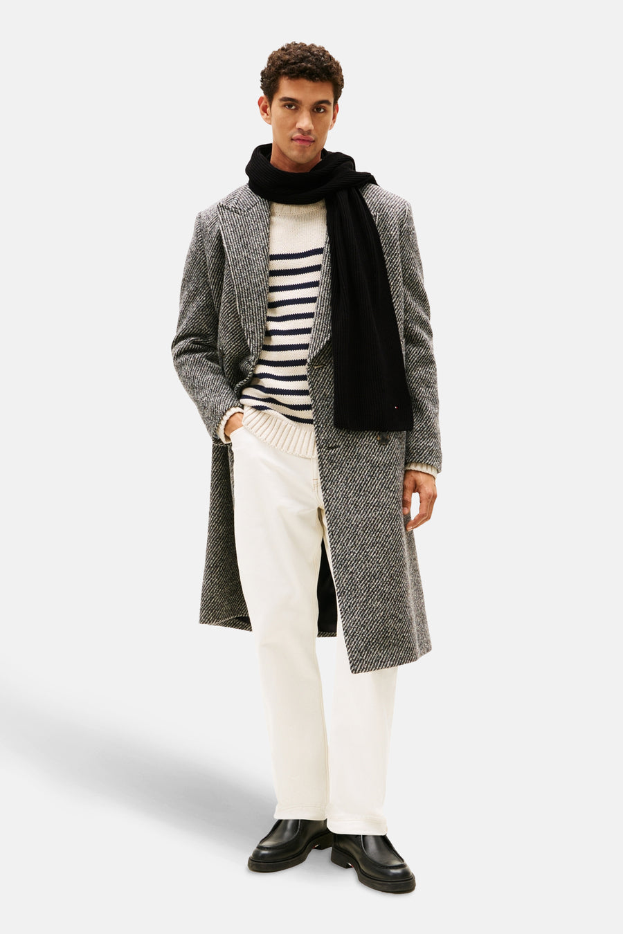 Zwarte sjaal van TOMMY JEANS, modeaccessoire gedragen met een visgraatmantel en een gestrepen trui.