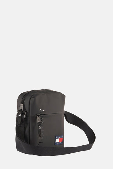 Zwarte schoudertas van TOMMY JEANS, met vierkant rood, wit en blauw logo op de voorkant.