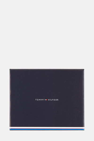Zwarte portemonnee van TOMMY JEANS, marineblauwe rechthoekige verpakking met logo.