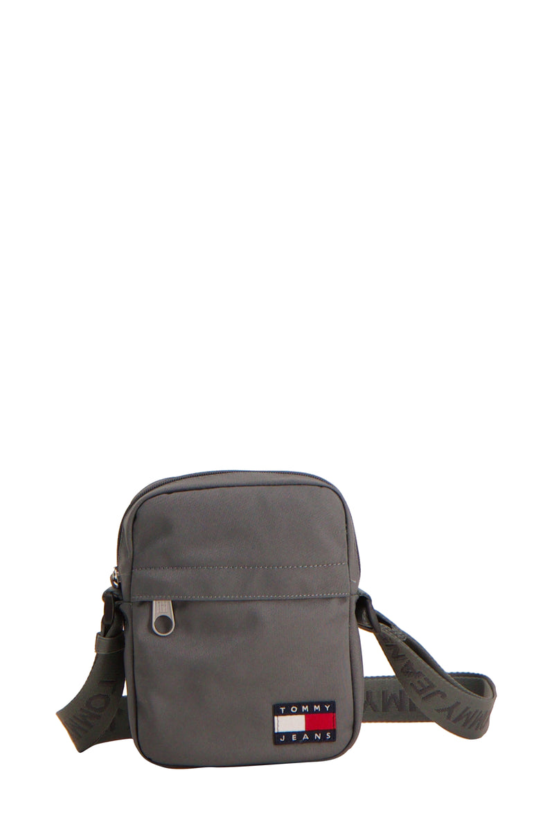 Sac à bandoulière gris de TOMMY JEANS avec bandoulière en tissu portant le nom de la marque.