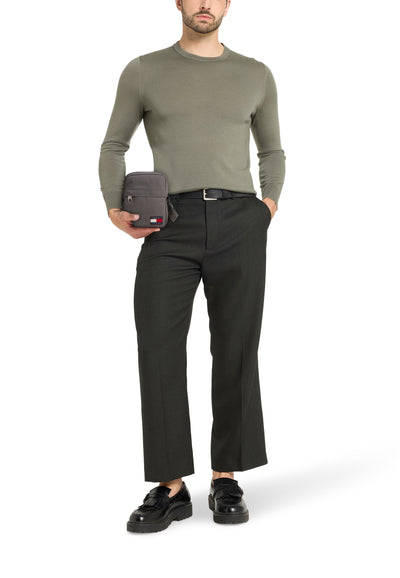 Grijze schoudertas van Tommy Jeans, gedragen met geruite trui en broek.